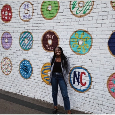 Crystal Sefah poses in front of a painted brick wall